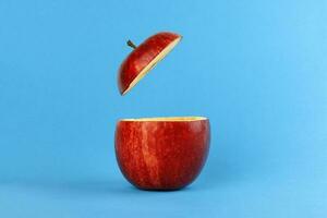 Health Red Cut Apple floating top slice juice drink idea concept on blue background photo