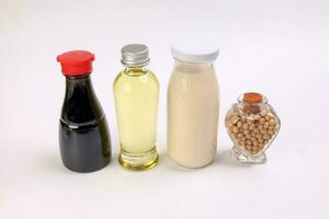 Soya beans in a hart shape bottle soya sauce milk oil in glass bottle on white background photo
