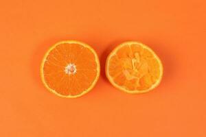 Mandarin Orange Fruit slice half juiced extracted on orange background photo