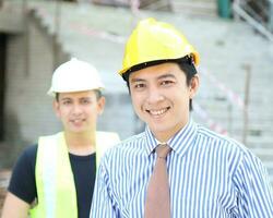 sur este asiático joven malayo chino hombre mujer vistiendo sin peligro casco construcción sitio trabajo foto