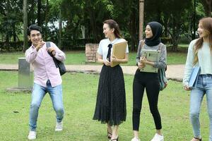 joven asiático malayo chino hombre mujer al aire libre parque libro archivo carpeta ordenador portátil computadora teléfono sentar estar estudiar mezclarse foto