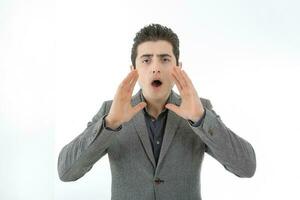Middle eastern Caucasian young office business man wearing suit hand on mouth calling shouting at camera on white studio background photo