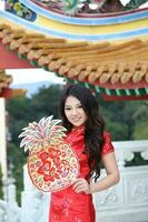 Young south east asian Chinese man woman traditional costume Chinese new year greeting outdoors at temple photo