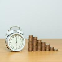 Money Saving for Future Plan, Retirement fund, Pension, Investment, Wealth Business and Financial concepts. coins money stack with clock on table photo