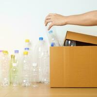 Volunteer keep plastic bottle into paper box at home or office. Hand Sorting Recycle garbage. Ecology, Environmental, pollution, Dispose recycling, waste management and trash Separation concept photo