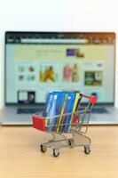 Shopping cart with Credit Cart and laptop computer with marketplace website. Online Shopping, technology, ecommerce, SEO, Search Engine Optimization, Advertising, keyword and online payment concept photo