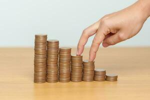 Money Saving for Future Plan, Retirement fund, Pension, Investment, Wealth, Salary and Financial concepts. hand step up coin on table, Money Counting and stack arrangement for Growth photo