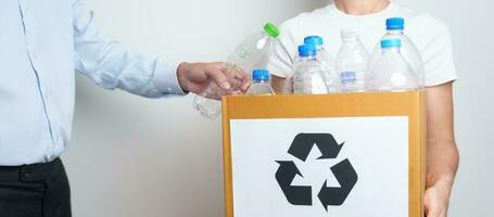 voluntario mantener el plastico botella dentro papel caja a hogar o oficina. mano clasificación reciclar basura. ecología, ambiental, contaminación, disponer reciclaje, residuos administración y basura separación concepto foto