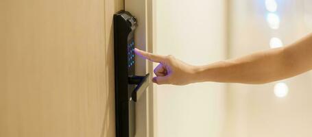 Hand press PIN number for smart digital door lock while open or close the door at home or apartment. NFC Technology, Fingerprint scan, keycard, smartphone and contactless lifestyle concepts photo