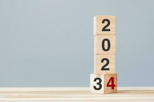 2023 chang a 2024 de madera cubo bloques en mesa antecedentes. resolución, plan, revisar, meta, comenzar, final año y nuevo año fiesta conceptos foto