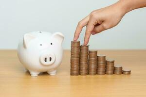 Money Saving for Future Plan, Retirement fund, Pension, Investment, Wealth, Salary and Financial concepts. hand step up coin with piggy bank on table, Money Counting and stack arrangement for Growth photo