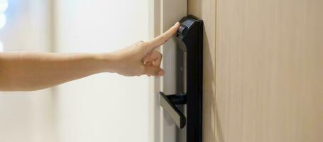 Hand using fingerprint scan for smart digital door lock while open or close the door at home or apartment. NFC Technology, keycard, PIN number, smartphone and contactless lifestyle concepts photo