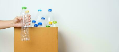 Volunteer keep plastic bottle into paper box at home or office. Hand Sorting Recycle garbage. Ecology, Environmental, pollution, Dispose recycling, waste management and trash Separation concept photo