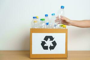 Volunteer keep plastic bottle into paper box at home or office. Hand Sorting Recycle garbage. Ecology, Environmental, pollution, Dispose recycling, waste management and trash Separation concept photo