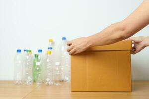 Volunteer keep plastic bottle into paper box at home or office. Hand Sorting Recycle garbage. Ecology, Environmental, pollution, Dispose recycling, waste management and trash Separation concept photo