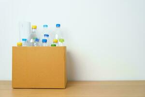 Plastic bottle in paper box at home or office. Recycle garbage Sorting. Plastic Free, Ecology, Environmental, pollution, Dispose recycling, waste management and trash Separation concept photo