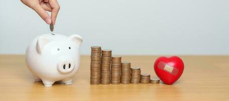 Money Saving, Health Insurance, Medical, Donation and Financial concepts. coins stack and piggy bank with red Heart shape, Money stack Counting arrangement for deposit and Healthcare cost photo