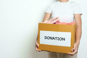 Donation, Charity, Volunteer, Giving and Delivery Concept. People donate Clothes into Donation box at home or office for support and help poor, refugee and homeless people. Copy space for text photo