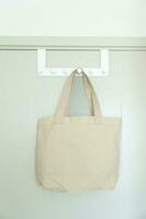 Eco friendly bag hanging on the door. Canvas Shopping tote bag. Zero waste, Reusable, Say No Plastic, Sustainability, World Environment day and Earth day concept photo