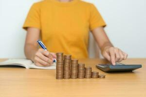 Money Saving for Future Plan, Retirement fund, Pension, Investment, Wealth Business and Financial concepts. Woman calculate and counting money coins on table photo