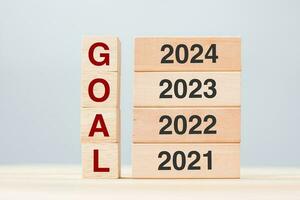 2024 block over 2023 and 2022 wooden building on table background. Business planning, Risk Management, Resolution, strategy, solution, goal, New Year New You and happy holiday concepts photo