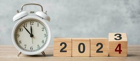 Happy New Year with vintage alarm clock and flipping 2023 change to 2024 block. Christmas, New Start, Resolution, countdown, Goals, Plan, Action and Motivation Concept photo