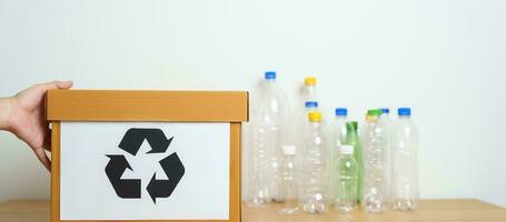 Volunteer keep plastic bottle into paper box at home or office. Hand Sorting Recycle garbage. Ecology, Environmental, pollution, Dispose recycling, waste management and trash Separation concept photo