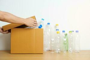 Volunteer keep plastic bottle into paper box at home or office. Hand Sorting Recycle garbage. Ecology, Environmental, pollution, Dispose recycling, waste management and trash Separation concept photo