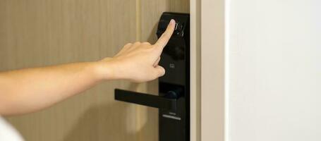 mano utilizando huella dactilar escanear para inteligente digital puerta bloquear mientras abierto o cerca el puerta a hogar o departamento. nfc tecnología, tarjeta de acceso, alfiler número, teléfono inteligente y sin contacto estilo de vida conceptos foto