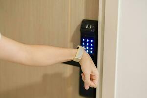 Hand using smartwatch for open digital door lock at home or apartment. NFC Technology, Fingerprint scan, keycard, PIN number, smartphone, electrical and contactless lifestyle concepts photo