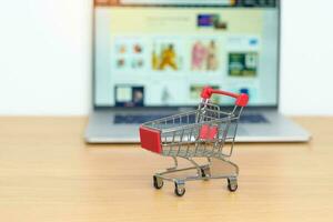 Shopping cart and laptop computer with marketplace website. Online Shopping, technology, ecommerce, SEO, Search Engine Optimization, Advertising, keyword and online payment concept photo