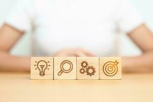 dartboard, Gear, magnifying and Lightbulb icon block on table. business planning process, goal, strategy, target, mission, action, research, teamwork and idea concept photo