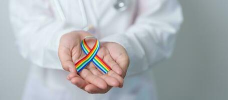 Doctor with LGBTQ Rainbow ribbon for Support Lesbian, Gay, Bisexual, Transgender and Queer community and happy Pride month concept photo