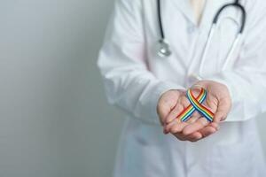 Doctor with LGBTQ Rainbow ribbon for Support Lesbian, Gay, Bisexual, Transgender and Queer community and happy Pride month concept photo