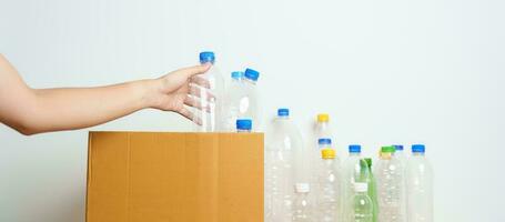 Volunteer keep plastic bottle into paper box at home or office. Hand Sorting Recycle garbage. Ecology, Environmental, pollution, Dispose recycling, waste management and trash Separation concept photo