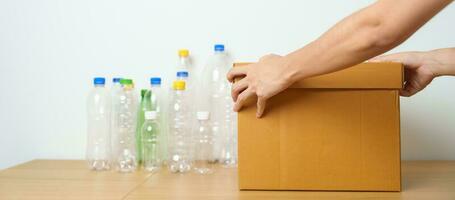 Volunteer keep plastic bottle into paper box at home or office. Hand Sorting Recycle garbage. Ecology, Environmental, pollution, Dispose recycling, waste management and trash Separation concept photo
