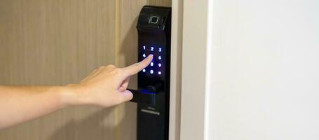 Hand press PIN number for smart digital door lock while open or close the door at home or apartment. NFC Technology, Fingerprint scan, keycard, smartphone and contactless lifestyle concepts photo