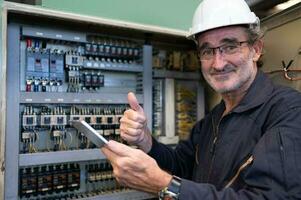 mayor ingeniero inspecciona el eléctrico sistema y refacción el mecánico sistema en el máquina controlar gabinete. en orden para el máquina a regreso a normal operación foto