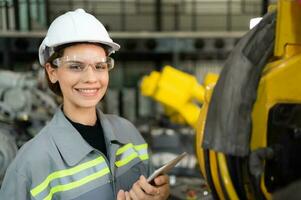 A female engineer installs a program on a robotics arm in a robot warehouse. And test the operation before sending the machine to the customer. photo