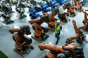 A female engineer installs a program on a robotics arm in a robot warehouse. And test the operation before sending the machine to the customer. photo