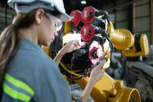 In the robots warehouse, A female engineer inspects the electrical system of every robotics arm, before delivering to the customer. photo