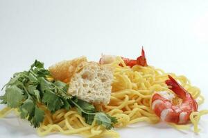 Fresh yellow egg noodle prawn tofu coriander leaf on whit background photo