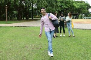 joven asiático malayo chino hombre mujer al aire libre parque caminar estar estudiar hablar discutir punto ordenador portátil archivo libro mochila contento adelante foto