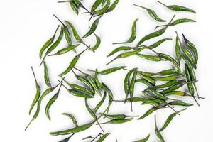 Fresh birds eye green chilli scattered top view on white background photo