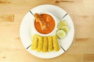 Traditional Malay snack food Roti Jala served with curry chicken with potato on white ceramic plate and bowl photo