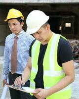 sur este asiático joven malayo chino hombre mujer vistiendo sin peligro casco construcción sitio trabajo foto