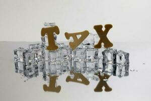 Tax alphabet ice cube freeze cool on white background photo