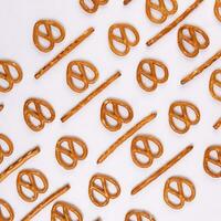 Pretzel cracker sticks laid in rows design angle straight on what background photo