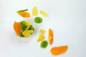 Dry preserved green kiwi pineapple ripe fruit slice colorful sweet on black marble slate background glass bowl flying floating elevated drooping photo