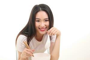 hermosa joven sur este asiático mujer participación chino vacío palillo sopa cuchara cuenco utensilio fingir interino posando ver comer gusto alimentar oferta satisfacción sabroso blanco antecedentes contento foto